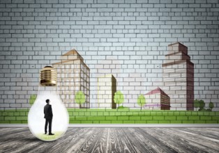 Businessman inside light bulb against city drawn concept