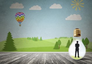 Businessman inside light bulb in room against nature drawn concept