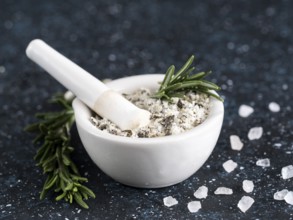 Close up view of mortar and pestle with sea salt scented rosemary and lemon zest. Sea salt scented