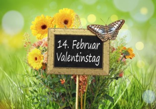 An image of a little chalkboard in the garden with the text 14th of february Valentines Day in