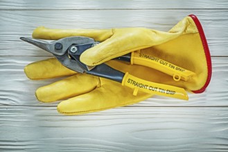 Protective gloves tin snip on wooden board