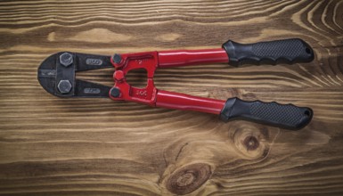 Bolt cutter on vintage wooden board construction concept