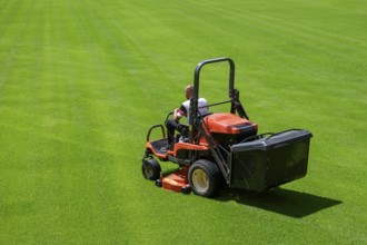 Mowing grass at the football stadium in Lubin, Poland, Europe