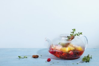 Immunity boosting drink. Winter Tea with cranberries, orange, hibiscus and spices in glass teapot
