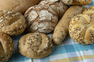 Heap of various bread rolls sprinkled with salt, caraway and sesame. Fresh rustic bread from