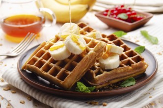 Homemade crispy Belgian waffles served with banana and honey