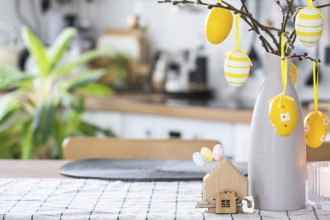 Key to house of cozy home with Easter decor with rabbit and eggs on table of kitchen. Building,