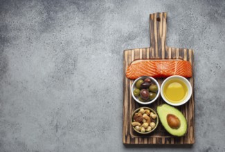 Food sources of healthy unsaturated fat and omega 3: fresh raw salmon fillet, avocado, olives, nuts