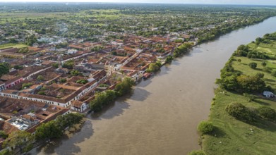 Aerial view of the historic town Santa Cruz de Mompox in sunlight with river and green