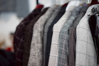 Colorful patterned blazers hanging on a rack in a store