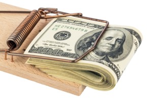Dollar banknotes in a mousetrap. Symbol photo for debt