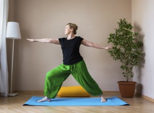 Middle aged or mature woman doing yoga indoors