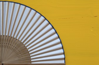 Typical Japanese hand fan made on the wooden yellow table