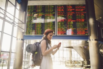 Theme travel and tranosport. Beautiful young caucasian woman in dress and backpack standing inside