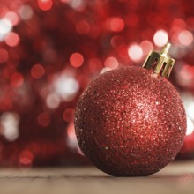 A red christmas bauble on the background of red boken