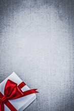 Present with red bow on metallic background copyspace holidays concept
