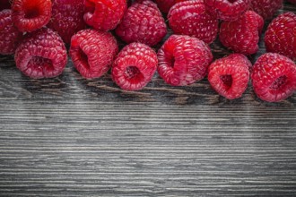 Raspberries on wooden background top view