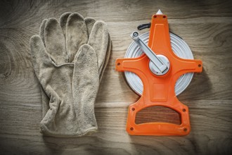 Safety gloves measuring tape on wooden board