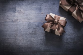 Gift containers with tied ribbons on wood board holiday concept