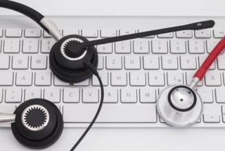 Office headphones with microphone over white keyboard on desk