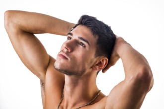 Handsome, fit shirtless young man isolated on white background, shot from above, looking away