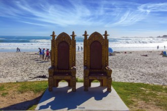 Two magnificent decorative chairs for tourist photography on the beach. Promenade and beach in