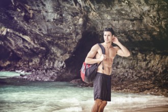 Half body shot of a handsome young man standing on a beach in Phuket Island, Thailand, shirtless