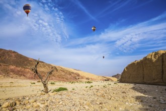 Stone desert near the seaside resort of Eilat. Three multi-colored balloons over the hot desert