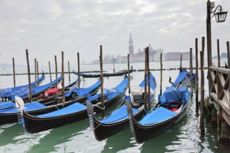 Gondolas with blue cover in Venice at the pier