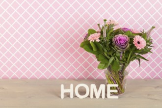 Colorful pink and purple bouquet in glass vase in interior