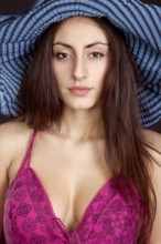 Pretty young girl face in hat on dark background