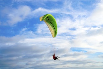 Man doing sport, Para-glider in the clouded sky. Paragliding is an extreme sport and recreation.