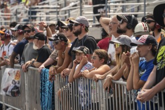 Fans watch as drivers race for position for the Crayon 301 at the New Hampshire Motor Speedway in