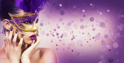 Beautiful woman with dramatic mekaup and pruple lipstick wearing puprle mask. Light background.