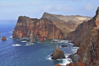 Red rocks and blue sea. Eastern end of Madeira Island at sunset. Deep Bay with picturesque islands