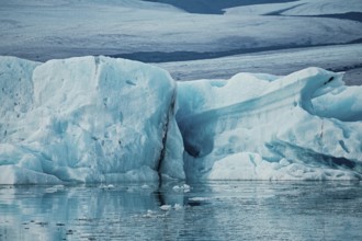 Large ice formations in a serene icy landscape with reflections on water, iceberg, glacier, snow,