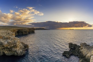 A sunset seascape in Malta with the Popeye Cliffs and a view of the ocean at Anchor Bay
