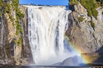 Magnificent rainbow in the spray of the waterfall Montmorency in Montmorency Falls Park. Above the
