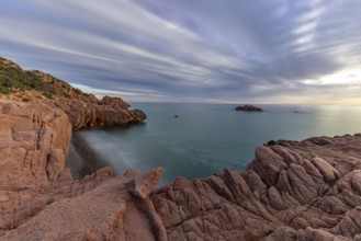Coast with bizarre red rocks and sea view at sunset, long exposure, Spiaggia di Cala E'Luas,