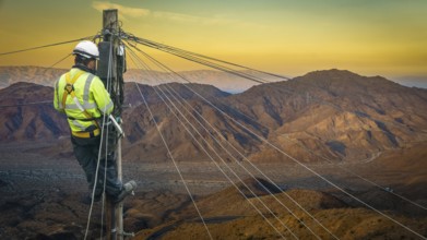 Lineman (Or Lineworker or Engineer) In A Remote Desert Landscape Fixing A Telephone Line