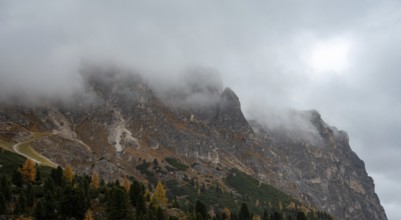 Cloudy fogy sky mountain peaks covered in mist in the morning. Dolomite rocky mountains Italy