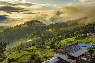 A village on the mountains under the light of sunrise through clouds