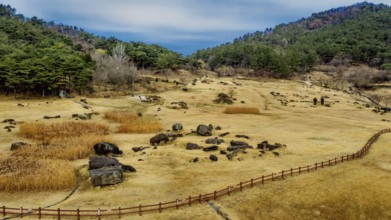 Gochang, South Korea. Dec. 4, 2024. Aerial view of dolmen tomb site with mountains and blue cloudy