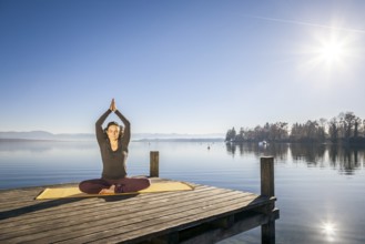 An image of a pretty woman doing yoga at the lake