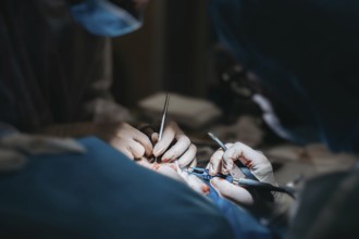 Surgeons in action performing surgery with focused lighting on their hands