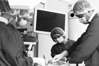 Surgery team operating in a surgical room