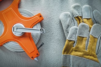 Set of protective gloves measuring tape on concrete background