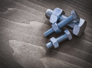 Construction nuts and screwbolts on brown wood board construction concept