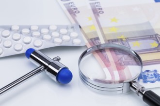 The photo shows a pack of tablets with a magnifying glass and money