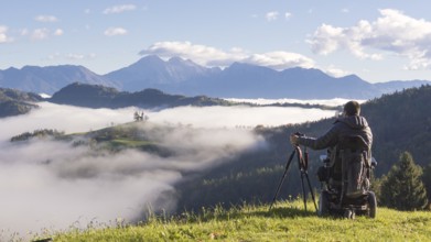 Man on wheelchair taking photos of beautiful landscape